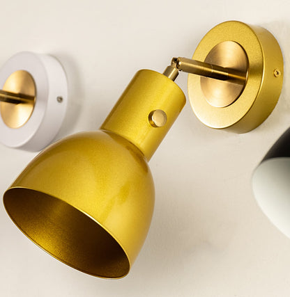 Closeup of gold metal wall light with cone shade for premium modern decor styling spaces.

