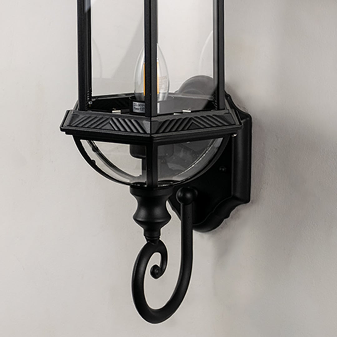 Closeup of lantern wall light highlighting detailed metal frame and clear glass panels.
