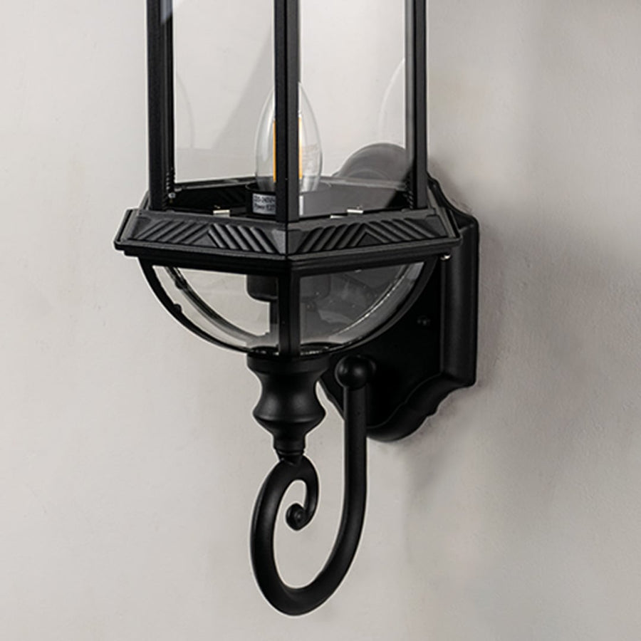 Closeup of lantern wall light highlighting detailed metal frame and clear glass panels.