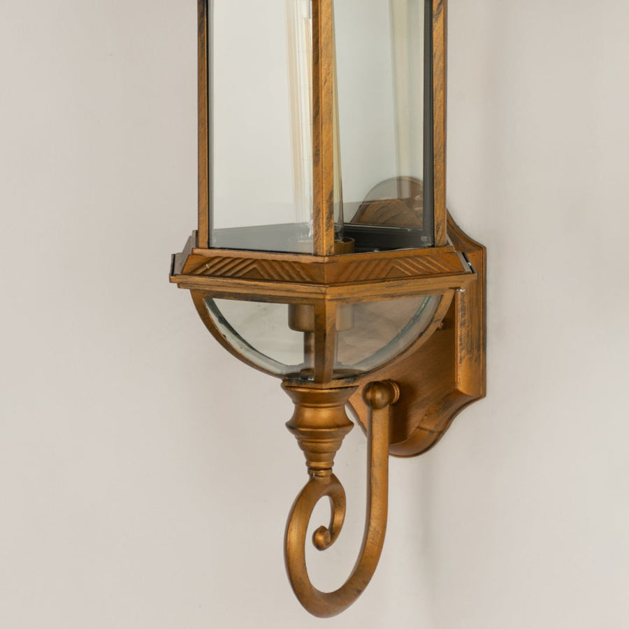 Closeup view of the antique bronze finish and scroll detail on the bottom of the classic glass wall lantern.