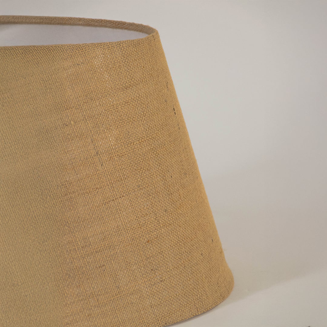 Closeup view of natural jute fabric lampshade highlighting woven texture and handcrafted detailing for warm interiors.