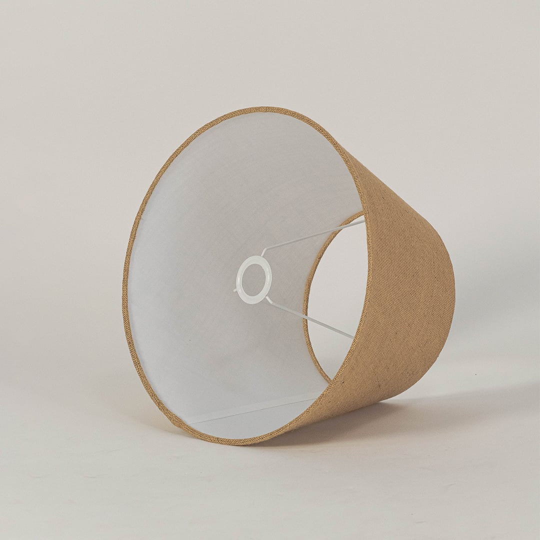 Handcrafted jute fabric lampshade with classic tapered shape and neutral finish for elegant home lighting.