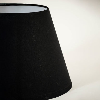 Detailed view of smooth black fabric texture and tapered shape of lamp shade highlighting premium material craftsmanship quality.