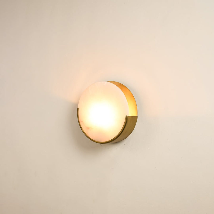 Elegant marble wall sconce with golden base illuminated on white background showcasing timeless beauty perfect for modern and classic decor.