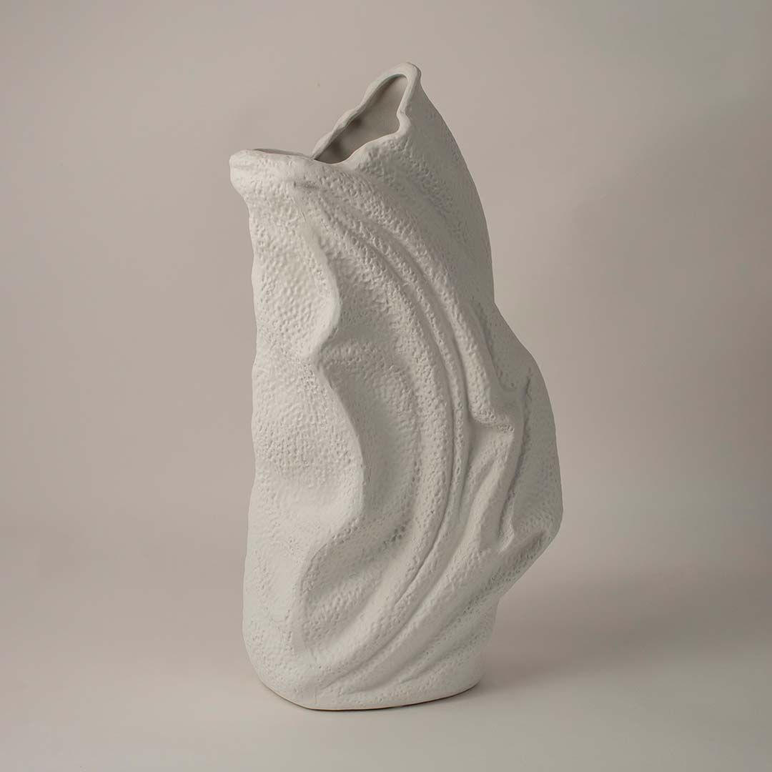 Side angle view of white ceramic decorative vase with sculptural wave texture ideal for living room or hallway decor.