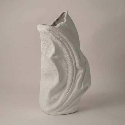 Side angle view of white ceramic decorative vase with sculptural wave texture ideal for living room or hallway decor.
