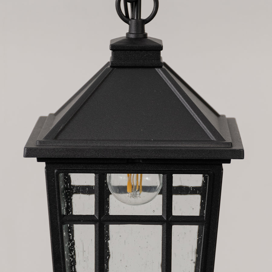 Closeup of black metal outdoor lantern light with clear glass panels on white background suitable for gate and pathway decor.