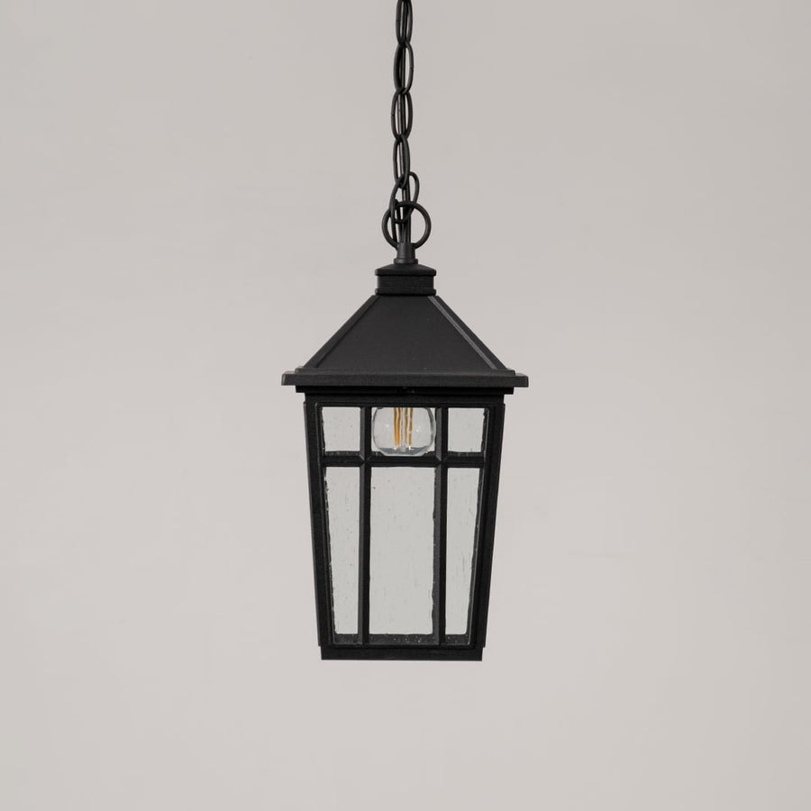 Traditional black hanging lantern with clear glass and chain suspension switched off displayed on minimal white backdrop.