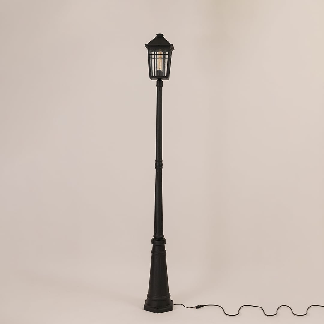 Tall outdoor post lamp in black metal shown unlit on off white background designed for pathway driveway and garden lighting.