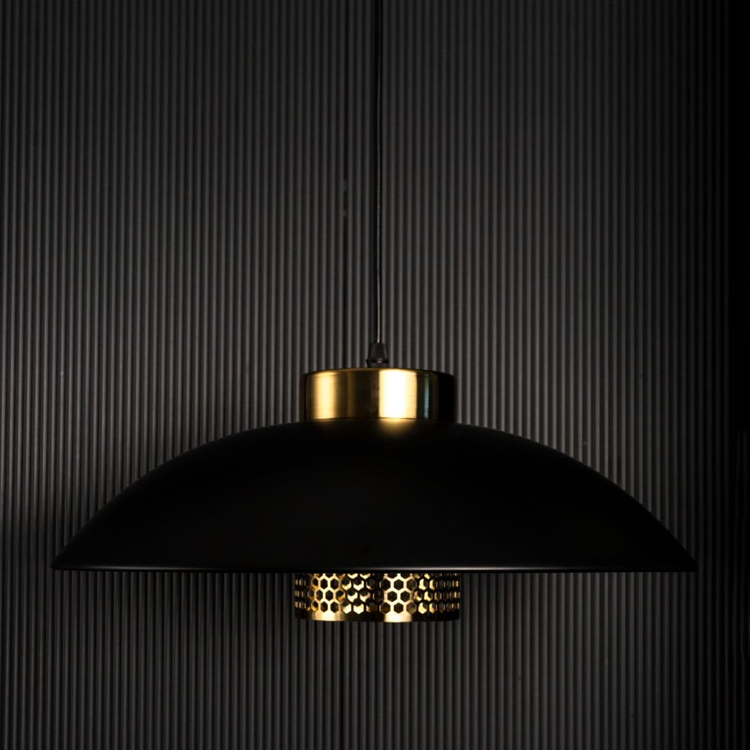 Designer pendant light with black metal shade and gold detailing shown unlit on black background for premium interior lighting design.