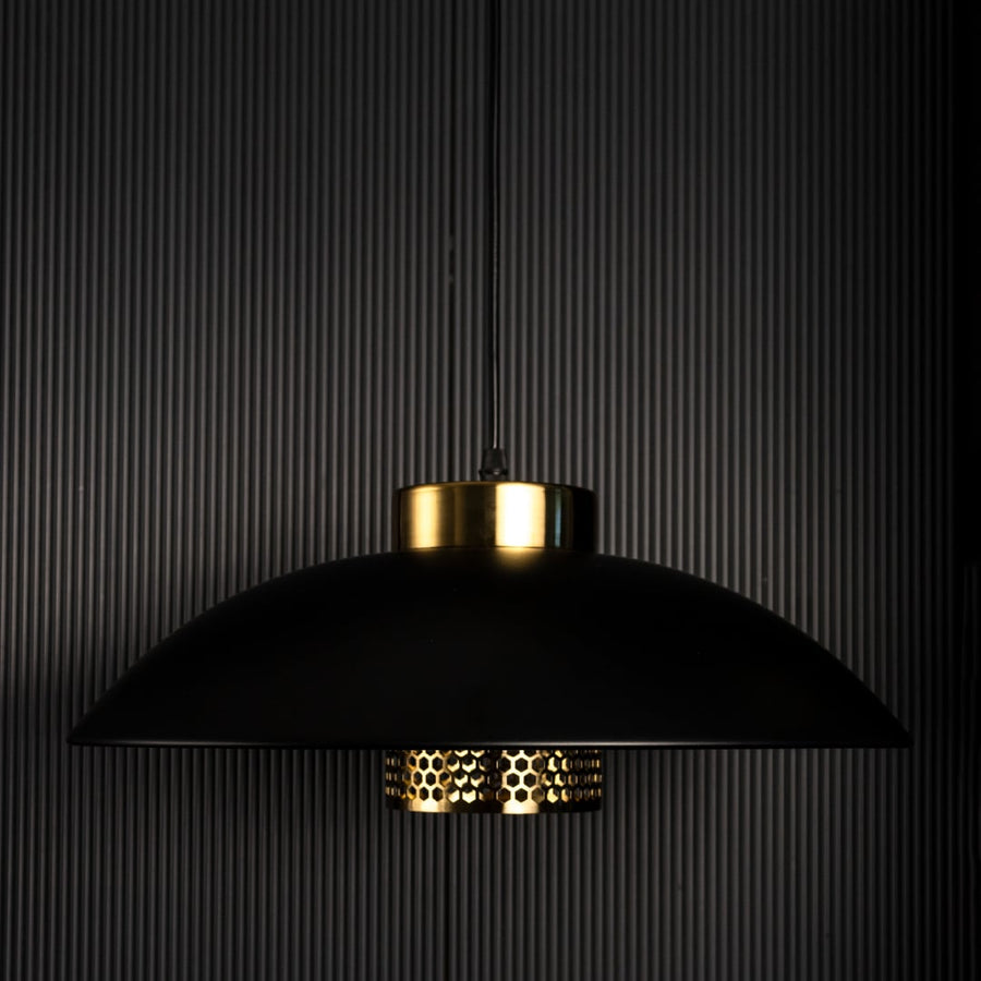 Designer pendant light with black metal shade and gold detailing shown unlit on black background for premium interior lighting design.