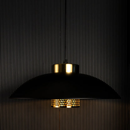 Black and gold metal pendant lights turned off together creating a stylish modern industrial ambiance on black background.