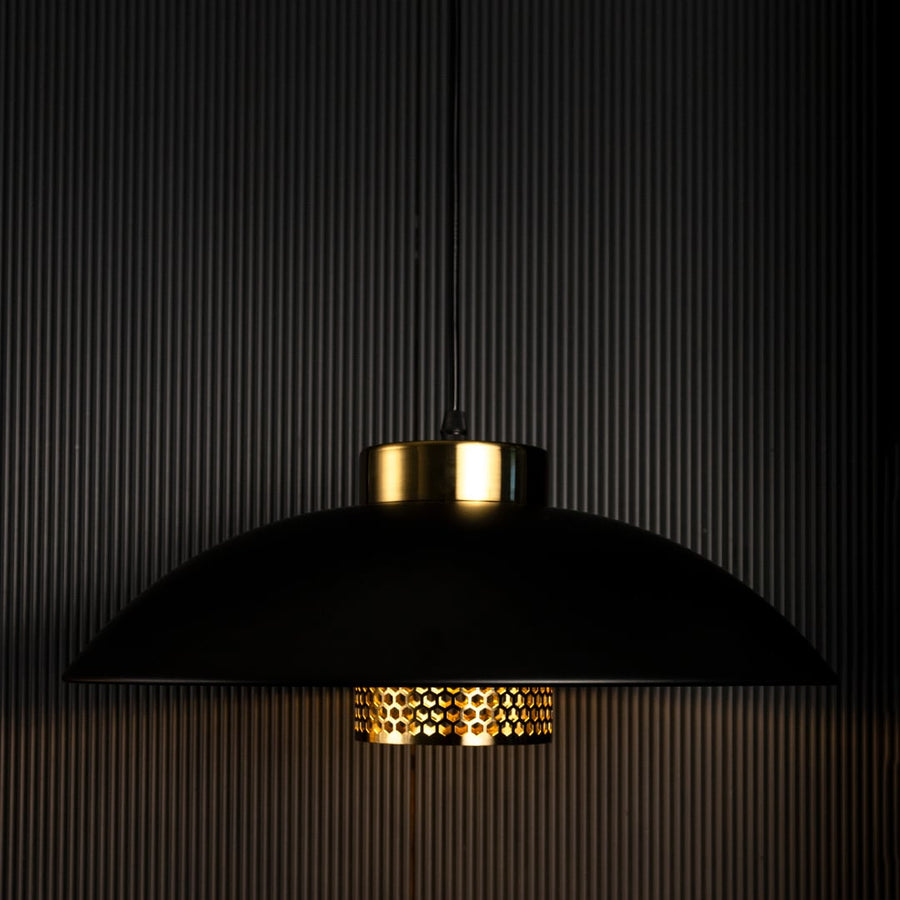Black and gold metal pendant lights turned off together creating a stylish modern industrial ambiance on black background.