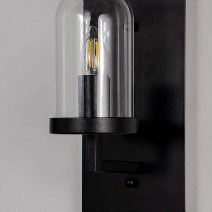 Closeup of black metal wall light with clear glass shade for modern hallway and luxury decor styling spaces.