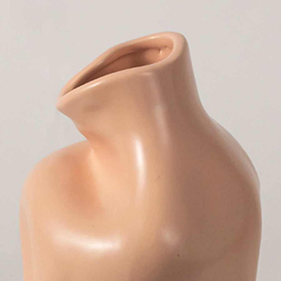 Closeup of beige sculptural ceramic vase showing curved design and matte texture ideal for contemporary home interiors.