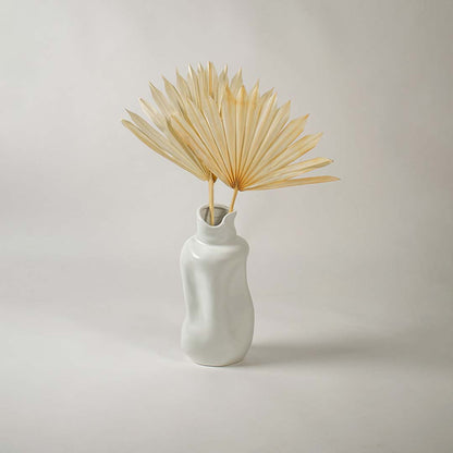Minimal white backdrop highlighting a sculptural ceramic vase with a modern fluid shape ideal for stylish interior decor.
