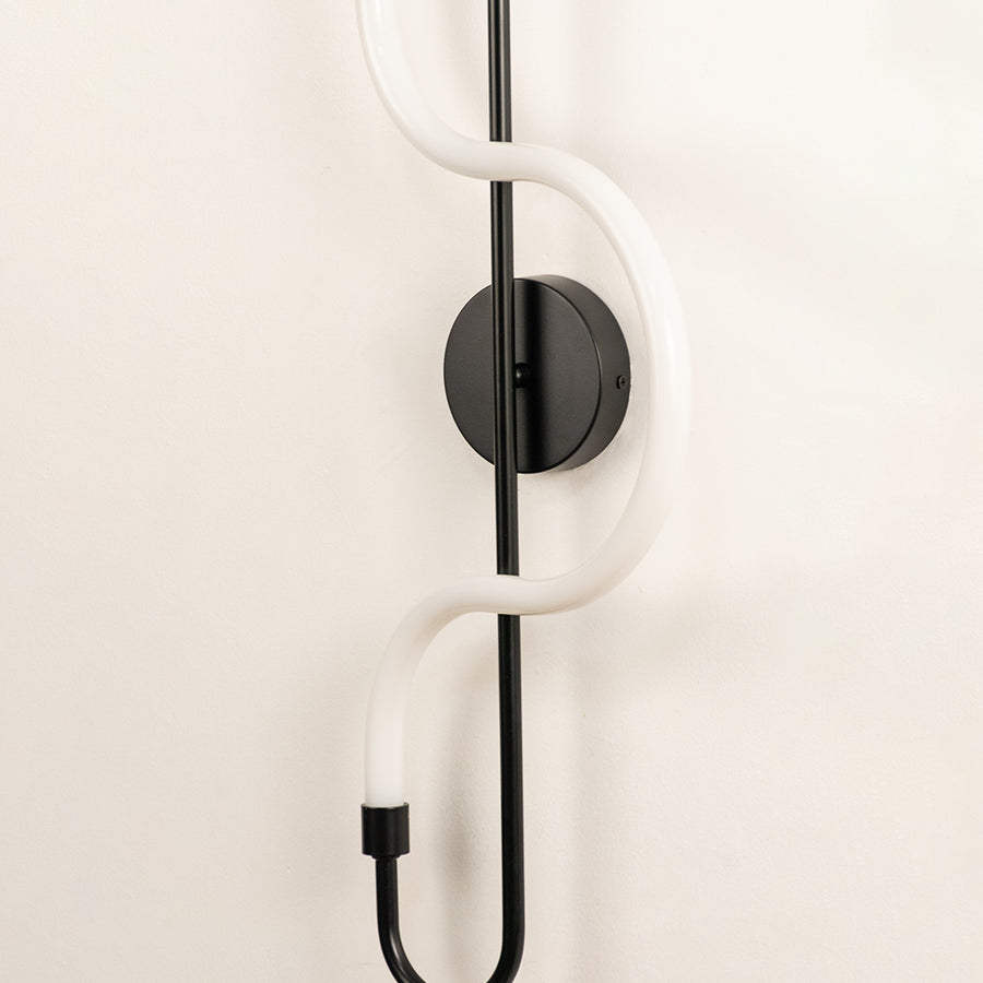 Minimal wall light closeup with white rod and black mount detail showing modern design and finish for indoor decor styling.