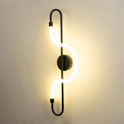 A stylish black metal LED wall lamp glowing brightly on a clean white wall perfect for decorative ambient lighting in contemporary interiors.