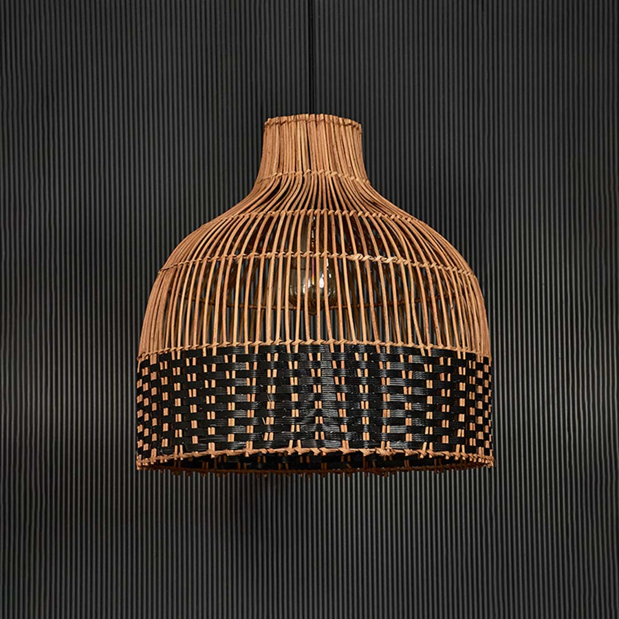 Two-tone rattan pendant light on black background highlighting intricate craftsmanship and balanced woven texture.
