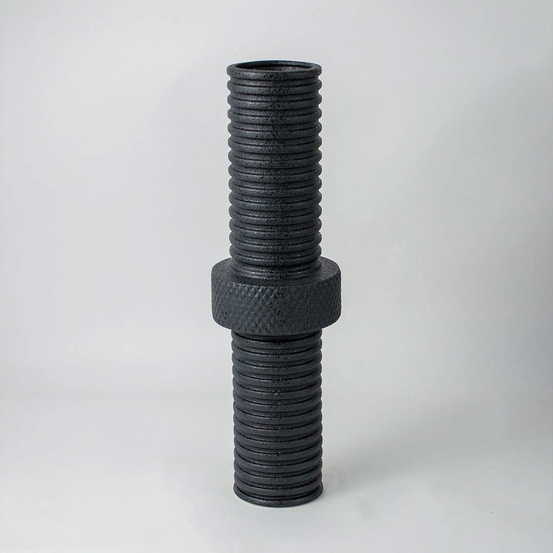 Modern matte black ridged cylindrical vase for minimalist home interiors and stylish contemporary table decor accents.