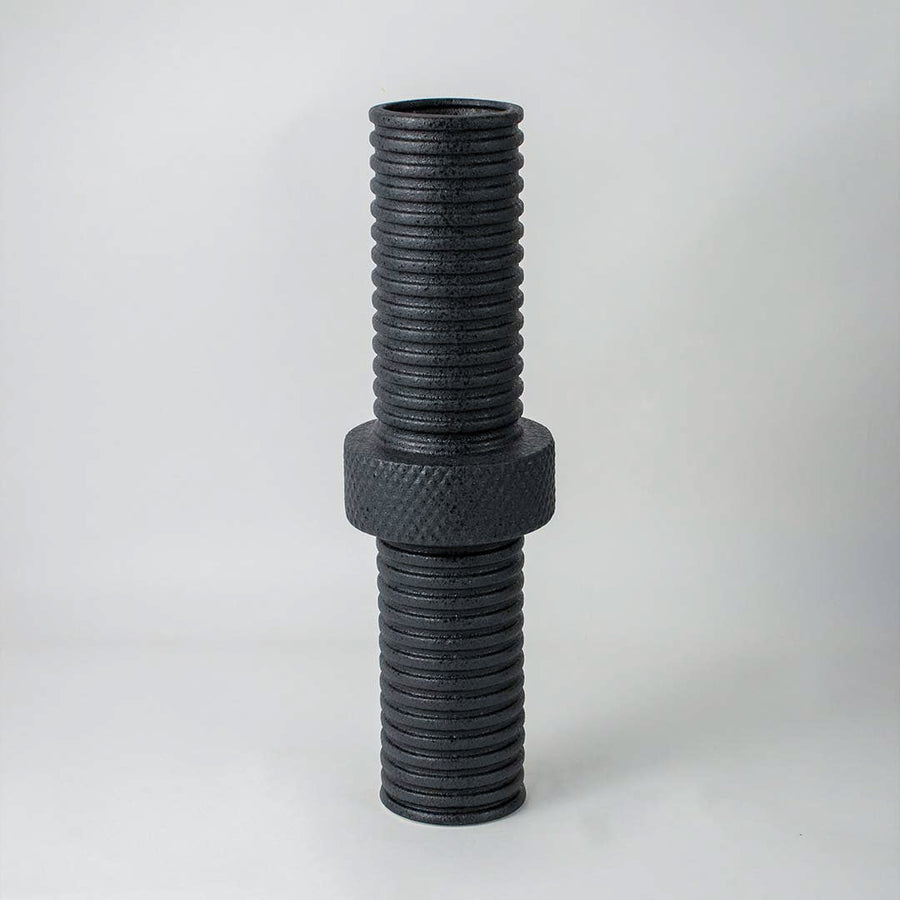 Modern matte black ridged cylindrical vase for minimalist home interiors and stylish contemporary table decor accents.