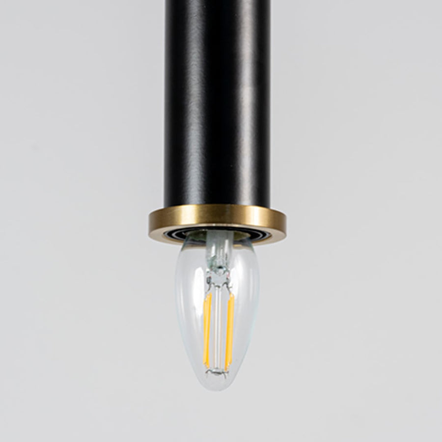 Closeup of black pendant ceiling lamp with golden rim featuring a cylindrical modern design lighting fixture.