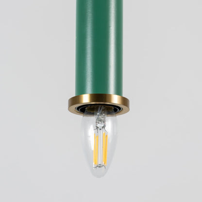 Closeup of green pendant light with brass ring and clear bulb turned on showing elegant ceiling decor detail.