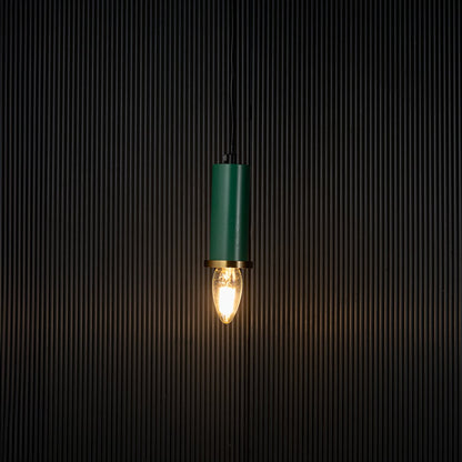 Stylish green pendant light turned on with warm glowing bulb creating ambient lighting effect on black background.