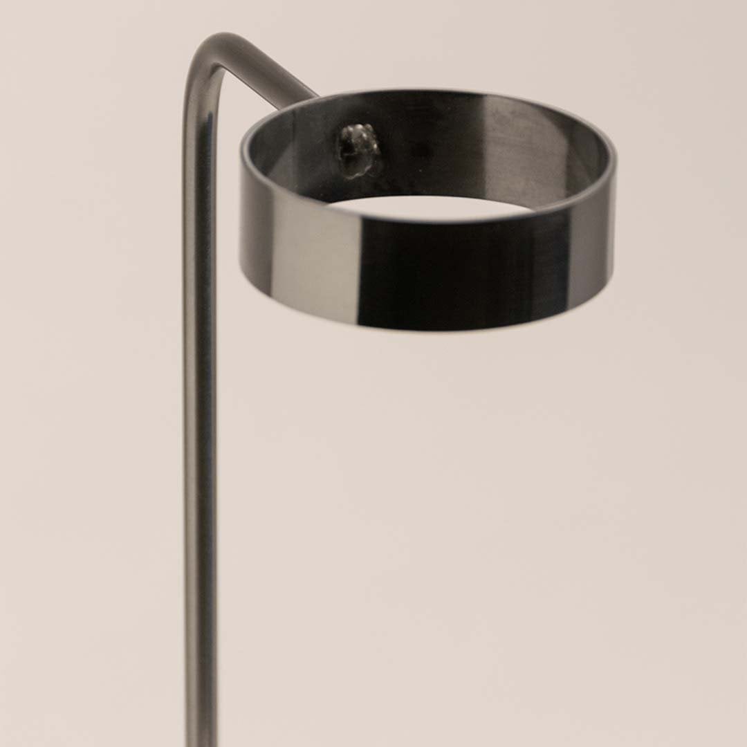 Closeup view of the metal stand vase showing its sleek black metal holder and marble base texture.