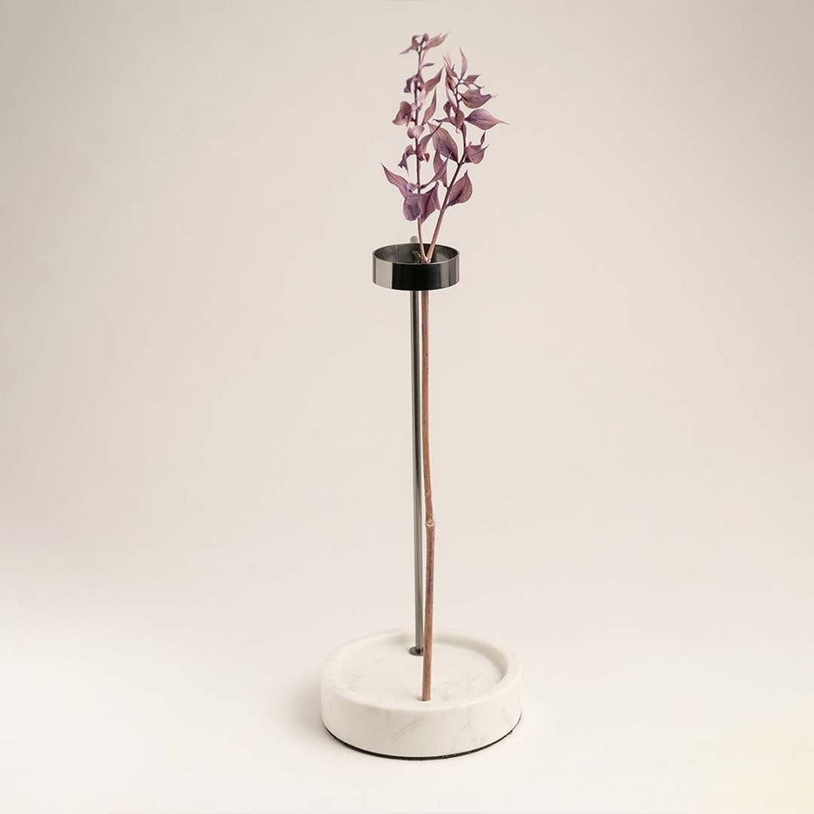 Metal stand vase on a clean white background emphasizing its black metal and marble base contrast.