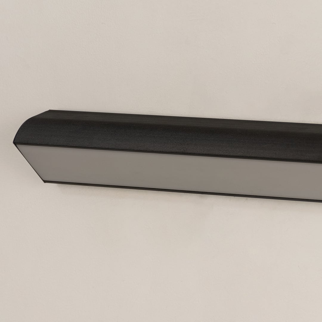 Closeup view of the matte black metal finish and white diffuser of the modern linear outdoor wall light fixture detail.
