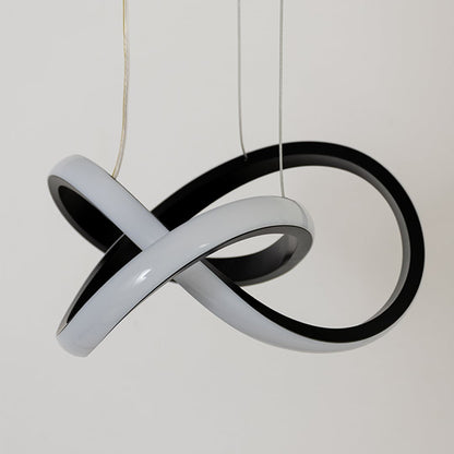 Closeup of sculptural pendant light with intertwined black and white rings showcasing smooth curves modern design and artistic lighting form.