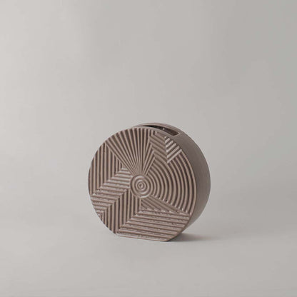 Matte brown round ceramic vase with etched geometric lines standing empty against a clean white background for display.