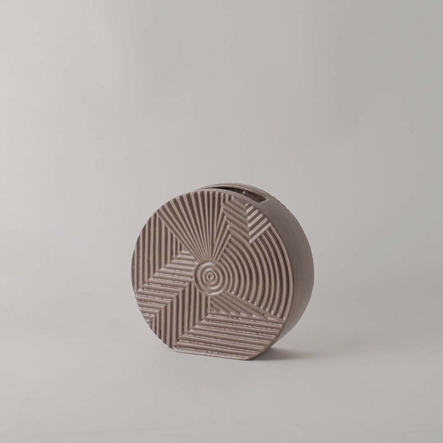 Matte brown round ceramic vase with etched geometric lines standing empty against a clean white background for display.