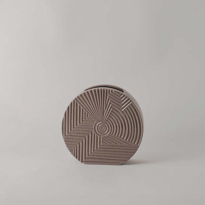 Matte brown round ceramic vase with etched geometric lines standing empty against a clean white background for display.
