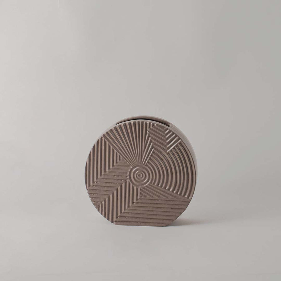Matte brown round ceramic vase with etched geometric lines standing empty against a clean white background for display.