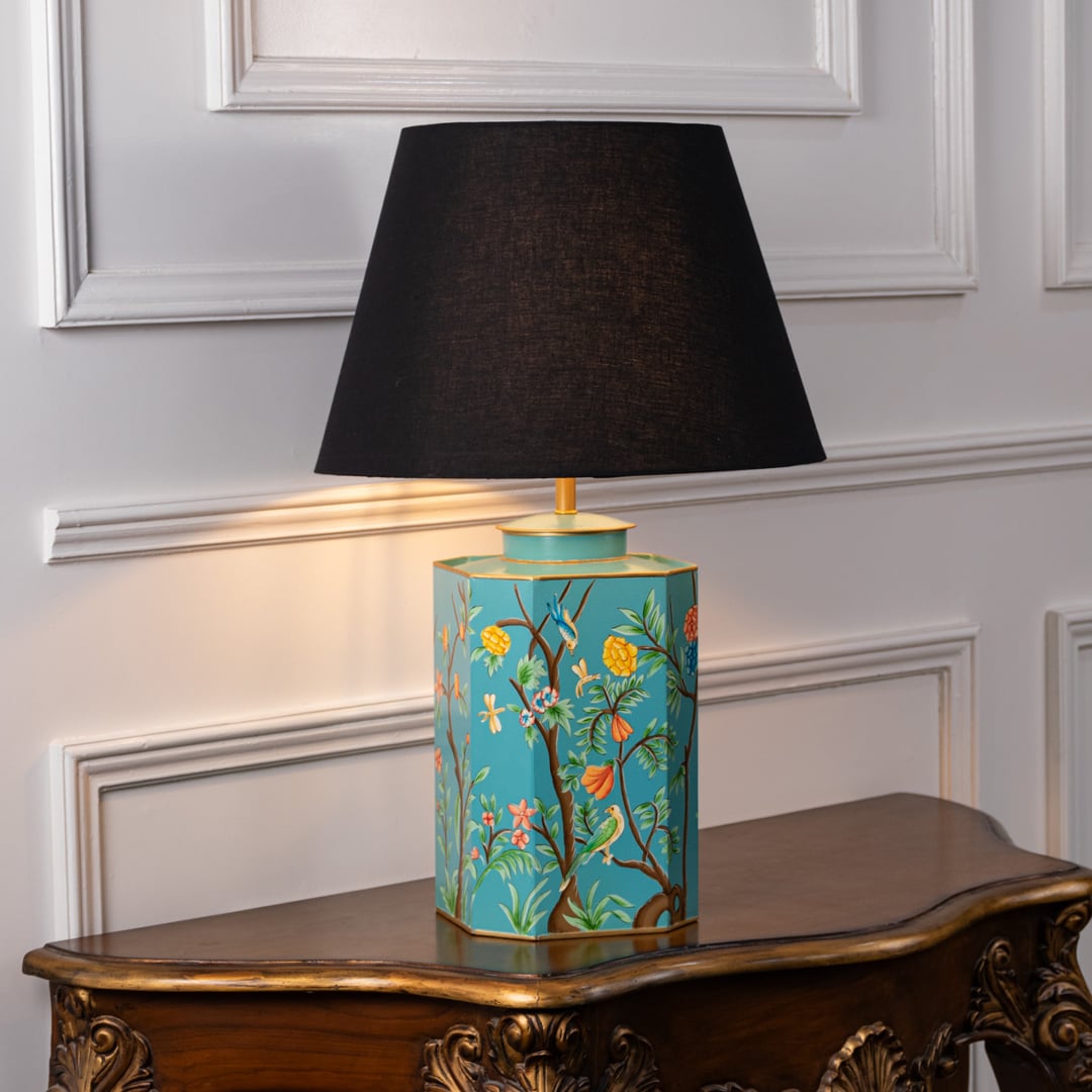 Elegant table lamp showing black shade and turquoise ceramic base with floral artwork and gold detailing for luxury home interiors.