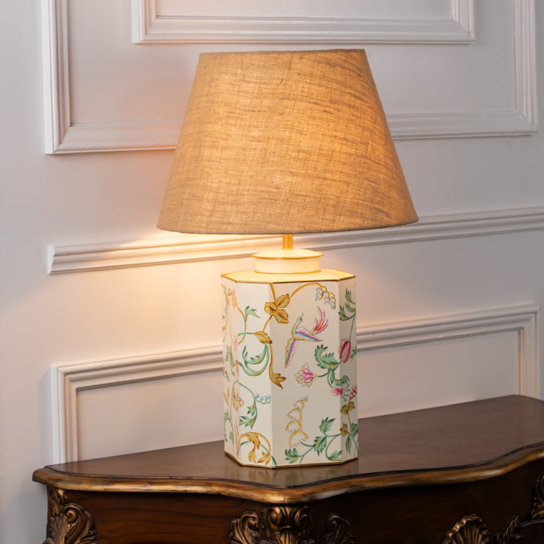 Lost Garden white table lamp on white background with light on offering subtle glow delicate pattern and airy interior decor style.