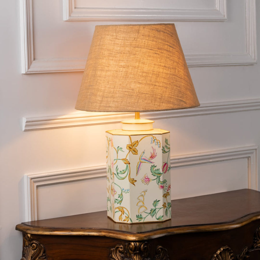 Lost Garden white table lamp on white background with light on offering subtle glow delicate pattern and airy interior decor style.