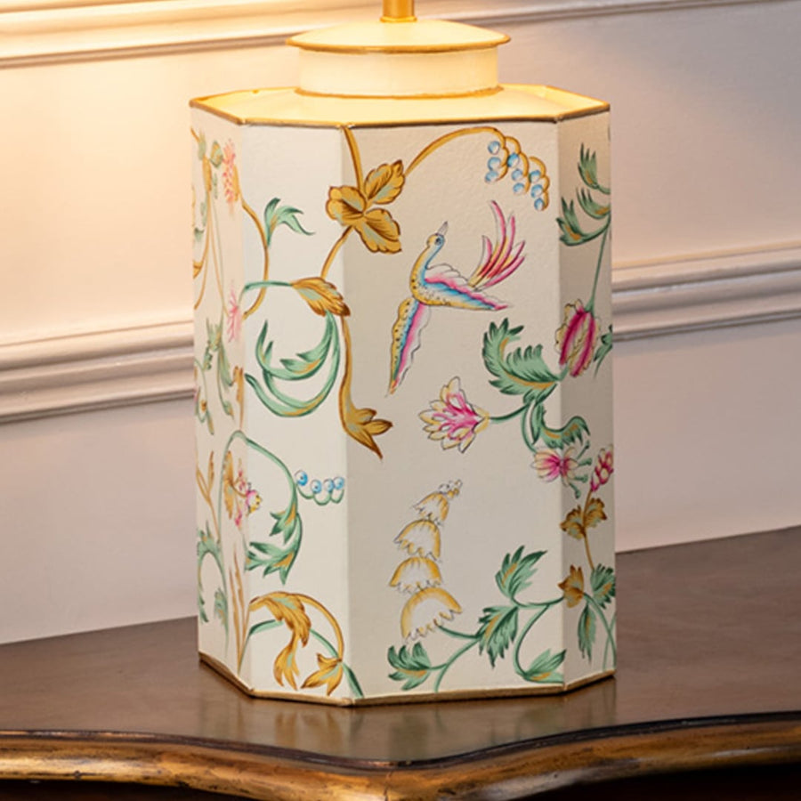 Table lamp closeup showing ceramic base with colorful floral and bird artwork finished with smooth glossy surface.