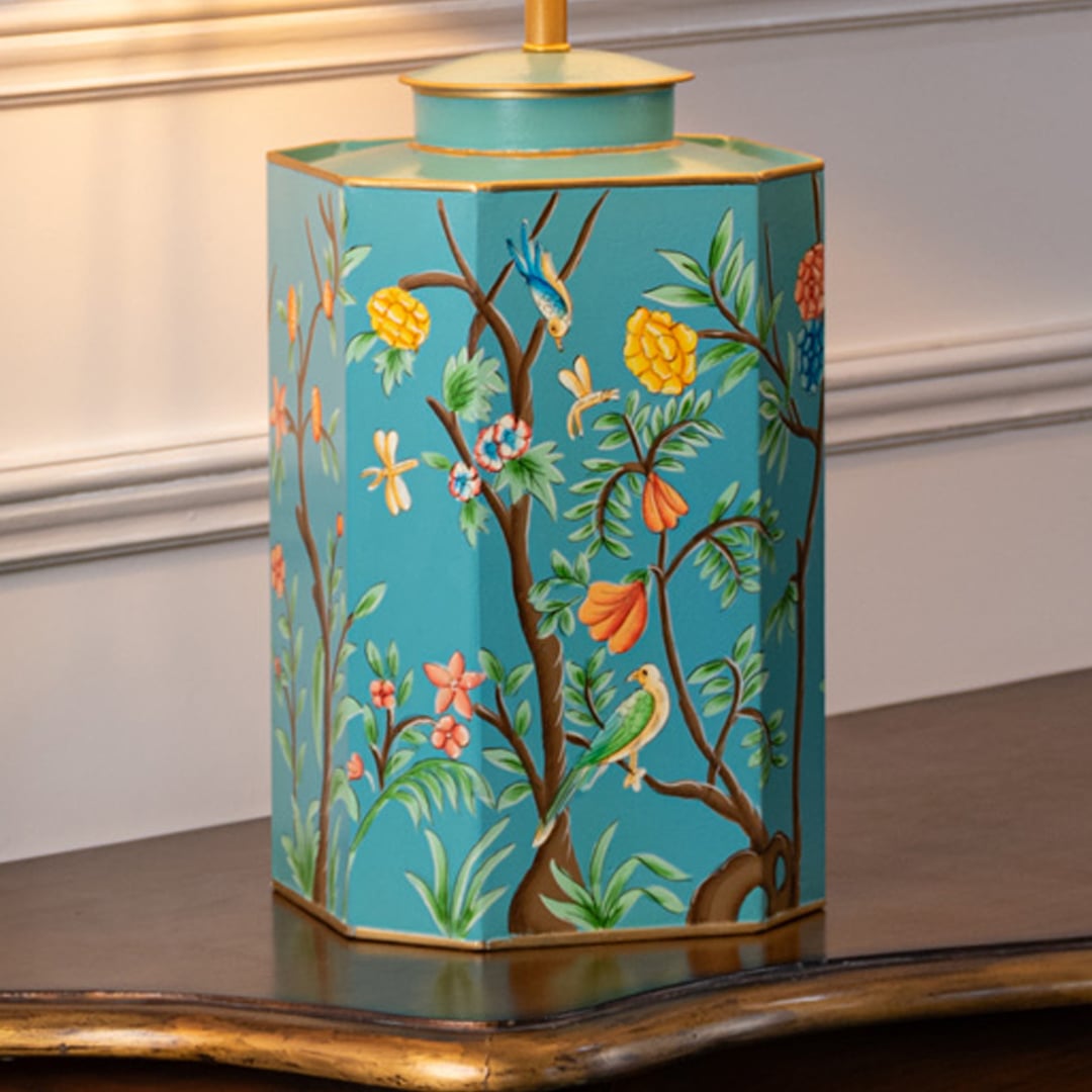 Table lamp closeup displaying turquoise ceramic base with floral artwork fine brush detailing and polished finish.