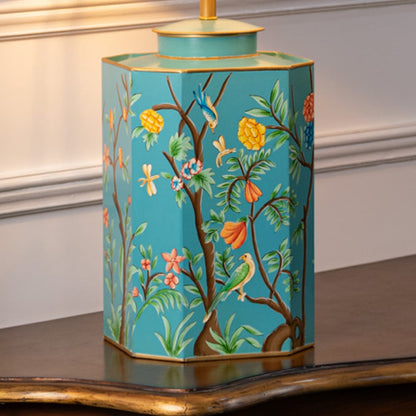 Table lamp closeup displaying turquoise ceramic base with floral artwork fine brush detailing and polished finish.