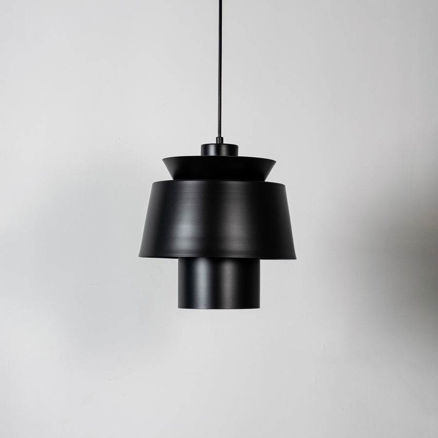 Black metal pendant light with layered geometric design and matte finish for sophisticated contemporary ceiling lighting decor.