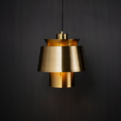 Contemporary gold pendant light turned on with black background for home lighting.