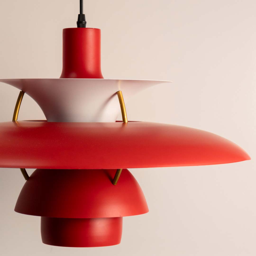 Closeup of red metal pendant light with layered shade showcasing premium craftsmanship and style.