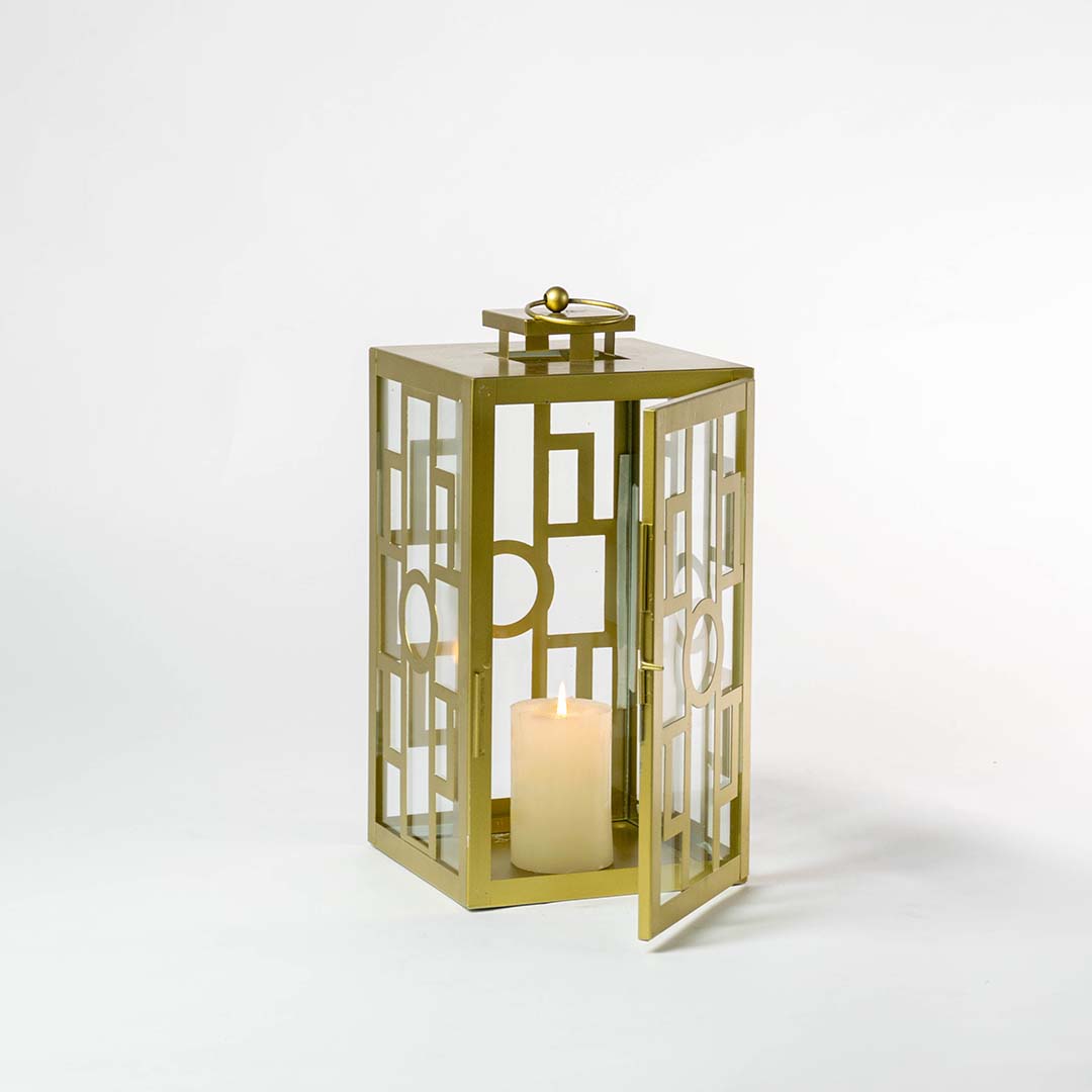 Gold metal lantern with geometric glass panels and candle holder for luxury tabletop decor styling.