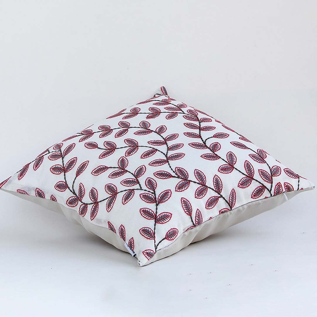 Soft cotton cushion cover with maroon botanical design shown at an angle offering a rich nature inspired décor accent with a breathable gentle and skin friendly fabric feel.