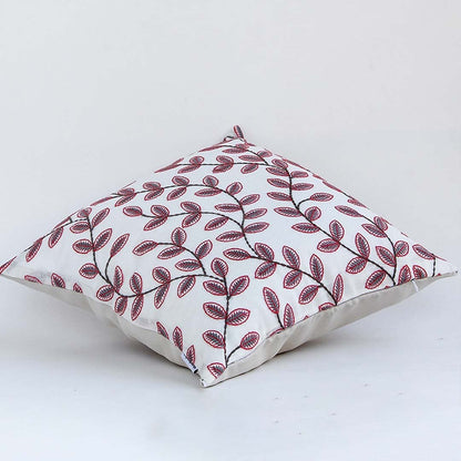 Soft cotton cushion cover with maroon botanical design shown at an angle offering a rich nature inspired décor accent with a breathable gentle and skin friendly fabric feel.
