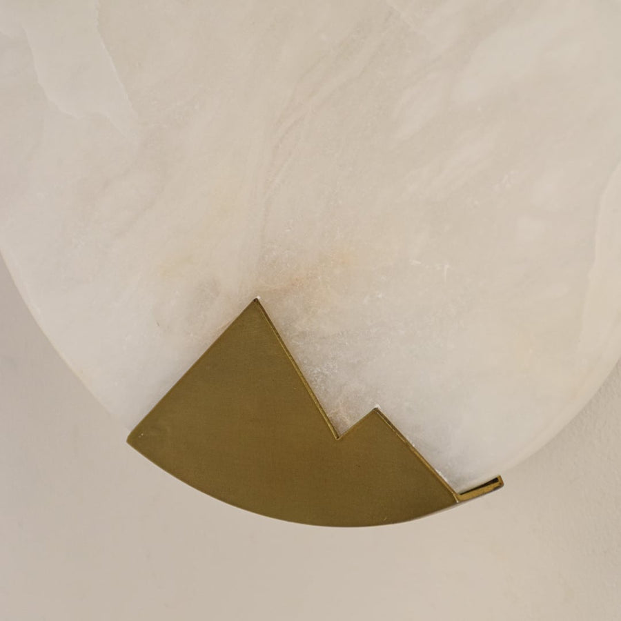 Closeup of marble wall light showing smooth stone finish and brass detailing showcasing refined craftsmanship and premium design quality.