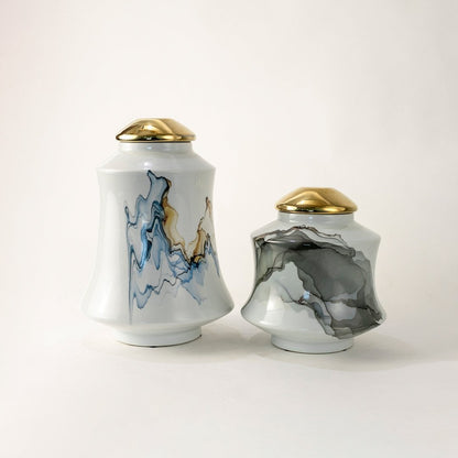 White ceramic jars with bold blue and gray abstract patterns topped with gold lids offering a modern artistic touch perfect for elevating refined tabletop décor.